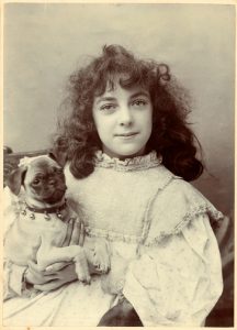 Vintage photograph of a cute victorian era girl and her pet dog circa 1880